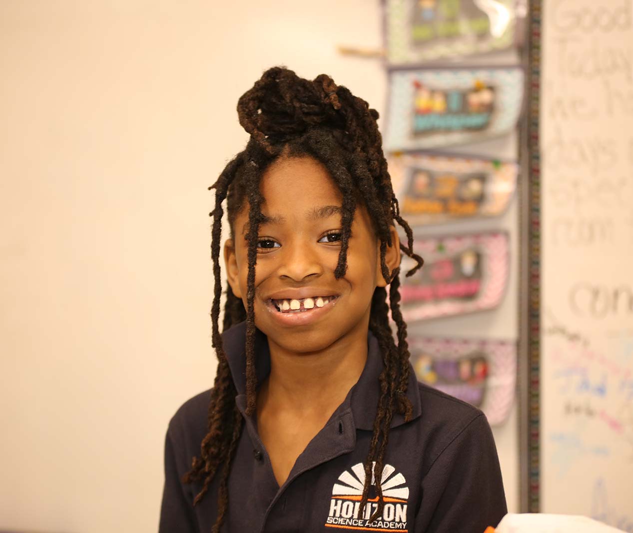 Student working on a notebook in a classroom.